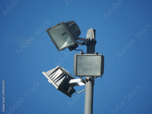 Three square spotlight combs on a pole on blue sky  photo