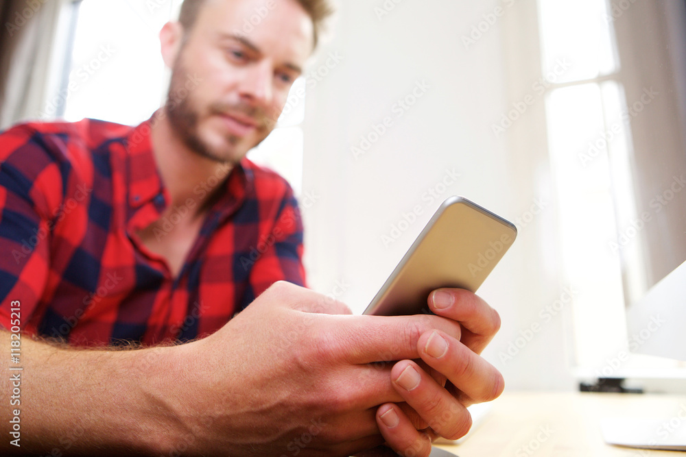 Handsome older man holding cellphone in hands at desk Handsome older man holding cellphone in hands at desk