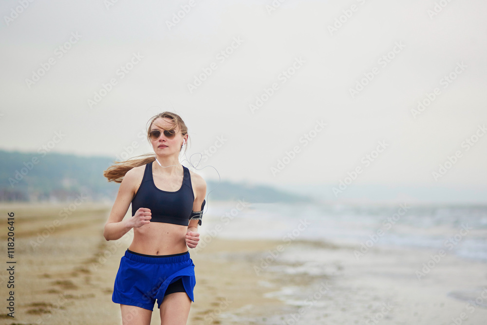 Young fitness running woman jogging on beach Young fitness running woman jogging on beach