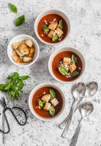 Cold tomato soup gazpacho with croutons and Basil on a light background. Vegetarian food, top view