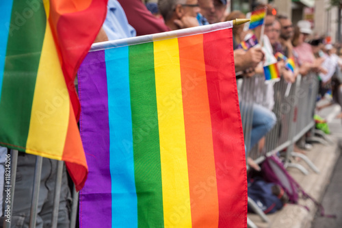Gay rainbow flags at Montreal gay pride parade with blurred spectators in background