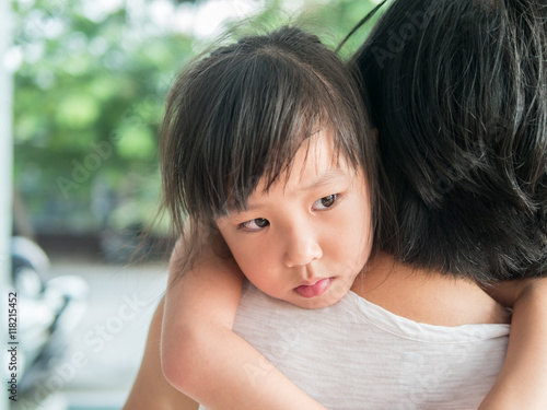 Asian baby girl hugging her mother , sleepy