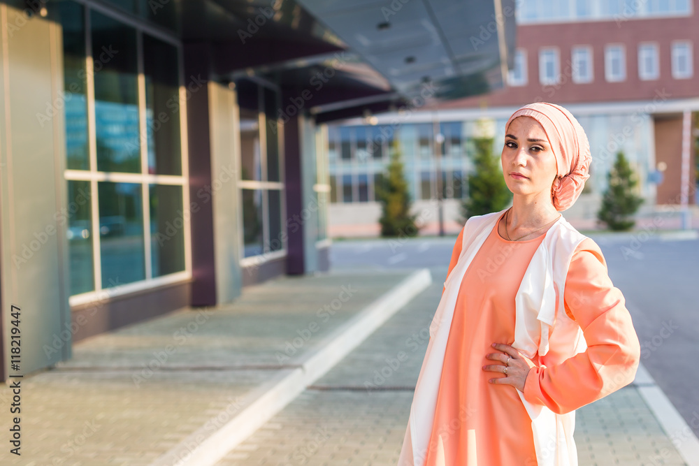 Young woman wearing hijab head scarf in city.