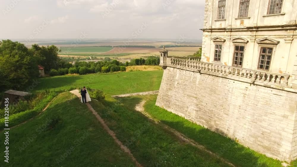 Aerial view of young wedding couple dancing at the castle on the descent. 4k Aerial view of young wedding couple dancing at the castle on the descent. 4k
