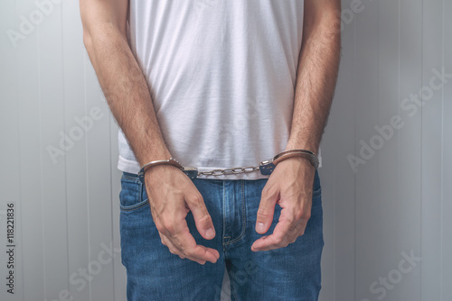 Arrested man with cuffed hands in front