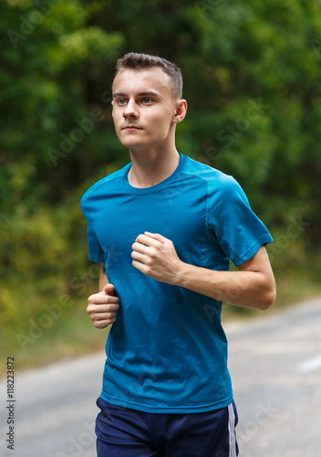 Boy jogging through forest