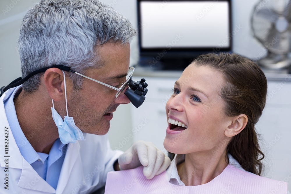 Dentist examining a female patient with dental loupes Stock Photo