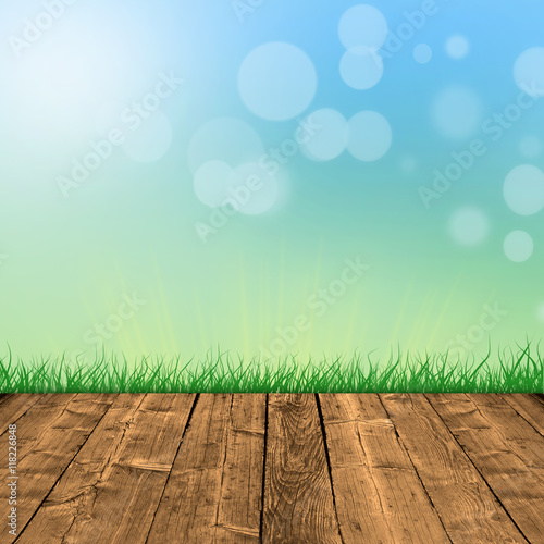 Fresh spring green grass with white bokeh and sunlight and wood floor.