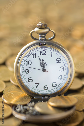 vintage pocket watch on the gold coins background