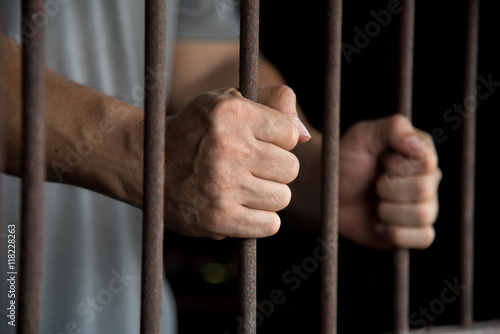 Fotografering Hands of the prisoner in jail