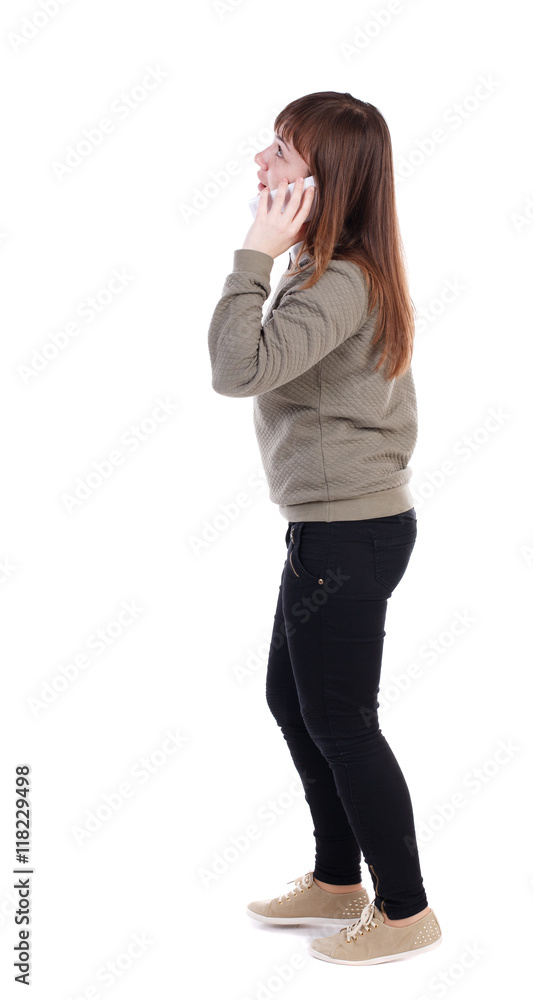 side view of a woman walking with a mobile phone. back view of girl in motion. backside view of person. Rear view people collection. Isolated over white background. A girl in a gray jacket talking side view of a woman walking with a mobile phone. back view of girl in motion. backside view of person. Rear view people collection. Isolated over white background. A girl in a gray jacket talking