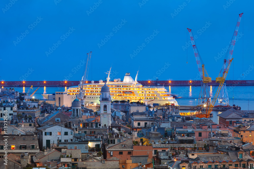 Aerial view of old town and port with cranes and ship at night, Genoa, Italy.
