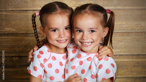 happy family children twin sisters hugging