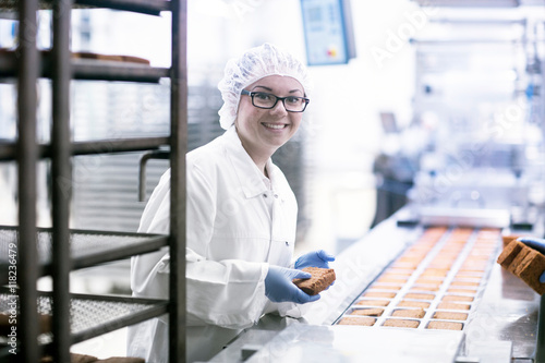 Factory worker on food production line looking at camera smiling