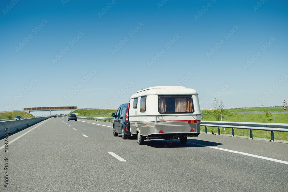 RV van and trailer driving fast to vacance destination on highwayon a summer day