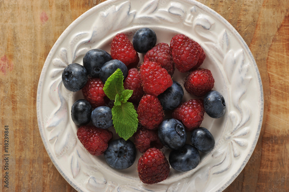 blueberries and raspberries with mint in bowl blueberries and raspberries with mint in bowl