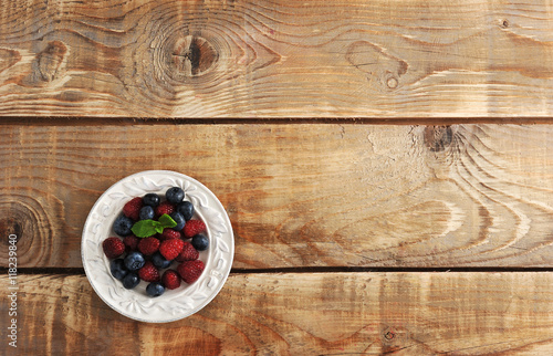 Fototapeta Naklejka Na Ścianę i Meble -  blueberries and raspberries with mint in bowl