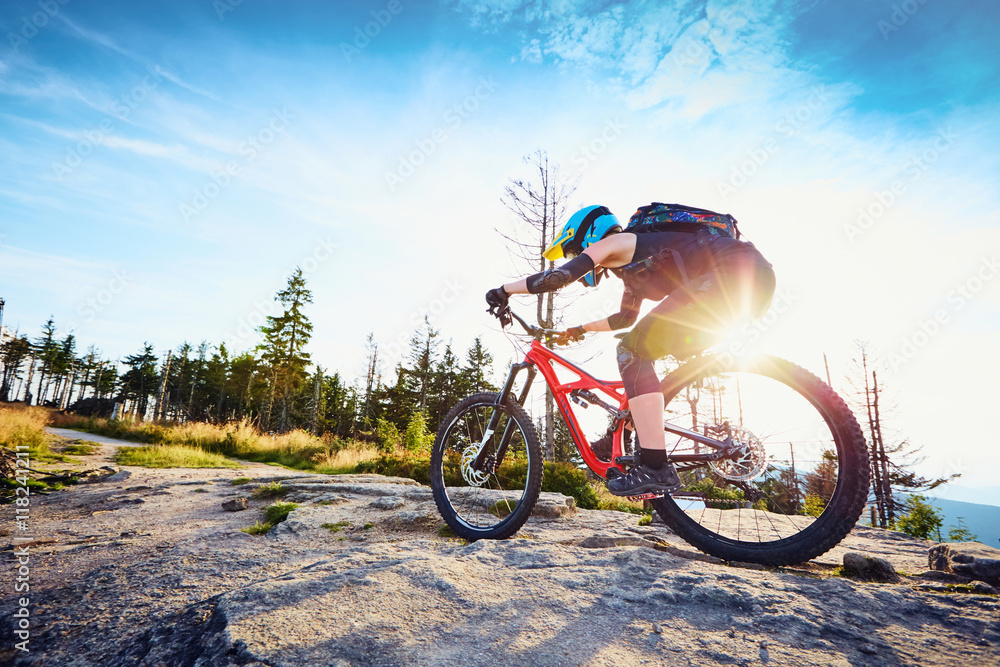 Fototapeta premium Female mountainbiker riding uphill in mountains