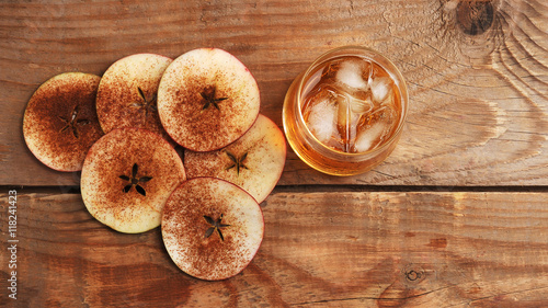 Apple cider with ice in a glass and slices of Apple