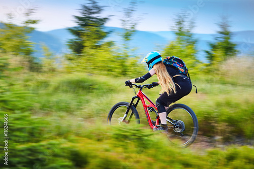 Blurred picture of woman riding on mountain bike in mountains