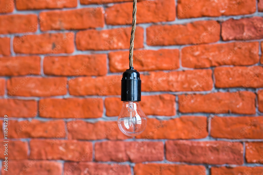 Incandescent lamp on a brick wall background Incandescent lamp on a brick wall background