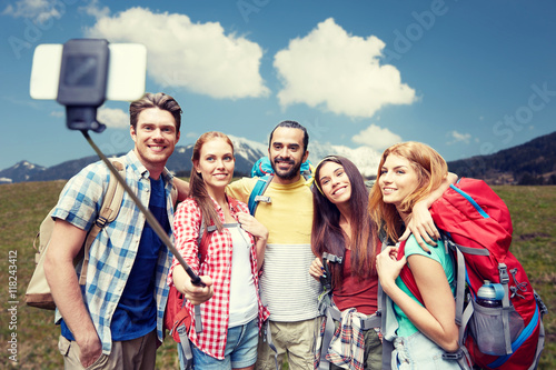 friends with backpack taking selfie by smartphone