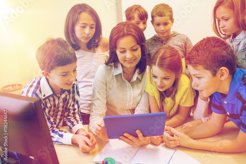 group of kids with teacher and tablet pc at school