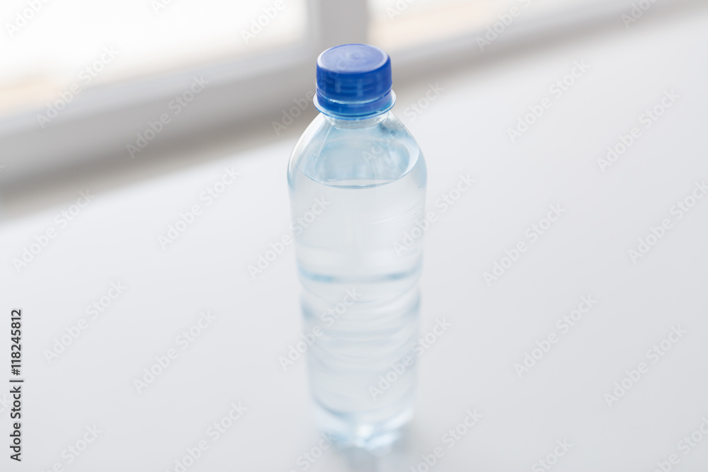 close up of bottle with drinking water on table close up of bottle with drinking water on table