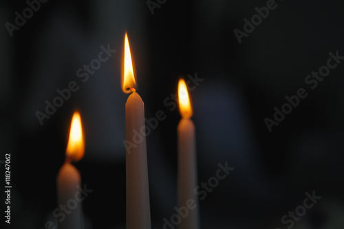 Three candles in dark room. Blurred background.