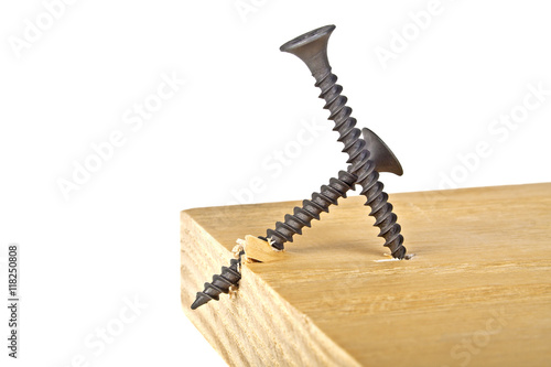 Screws screwed into wooden plank, white background