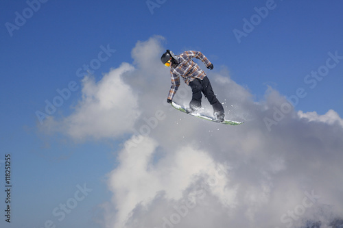 Snowboarder jumping in mountains, extreme sport.