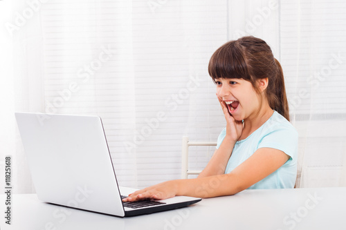 Excited little girl using laptop