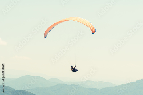 One paraglider in the sky over the hills line