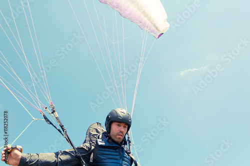 Low angle of male paraglider holding ropes
