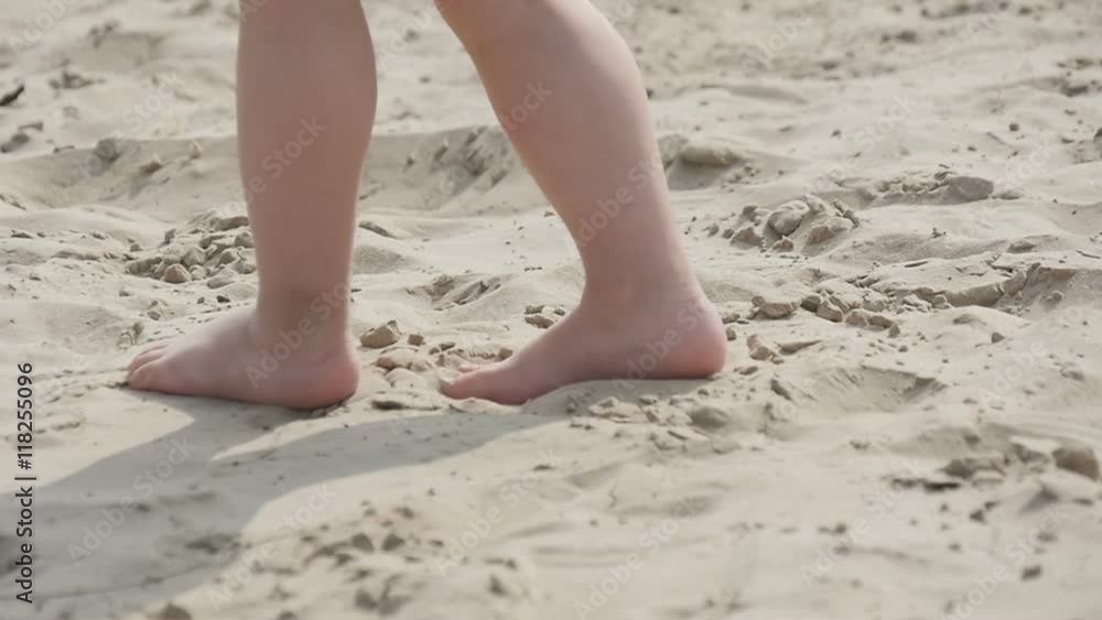 Children's legs running on the sand, slow motion Children's legs running on the sand, slow motion