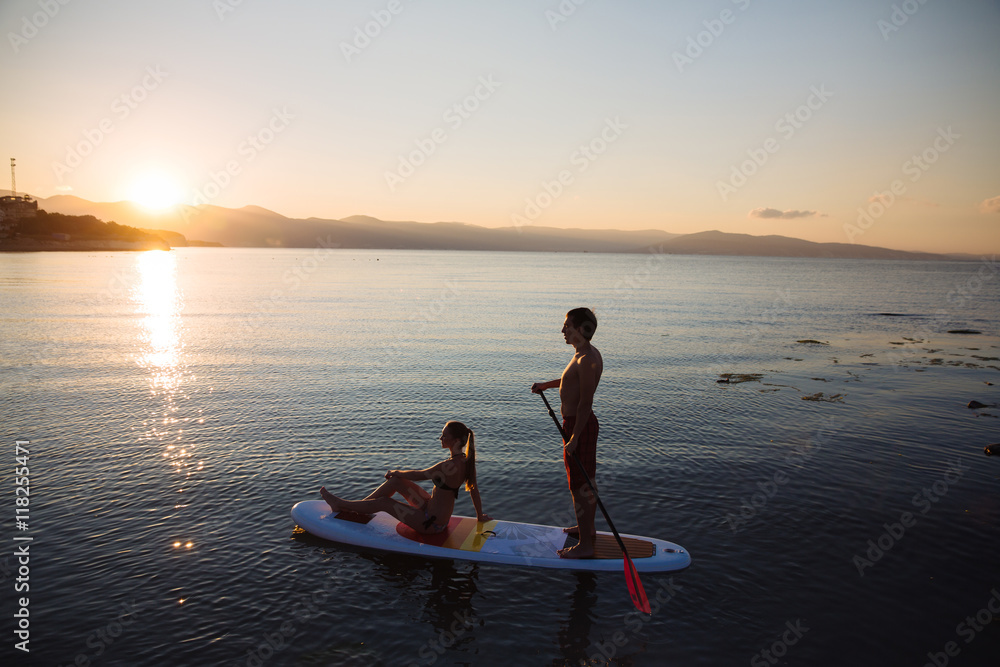 Fototapeta premium Silhouette of perfect couple engage standup paddle boarding