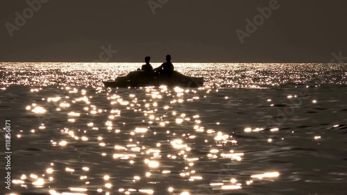  Beautiful seascape sunset with pedal boat silhouette refugee floating  photo