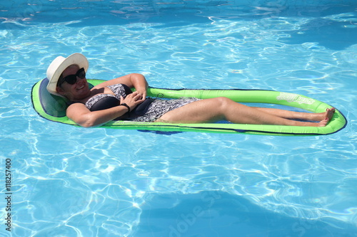 An english Lady relaxing in the swimming pool while on holiday