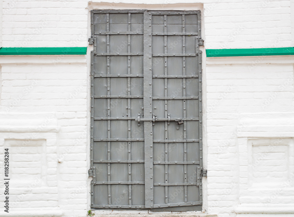 Large gray metal door on a white wall Large gray metal door on a white wall