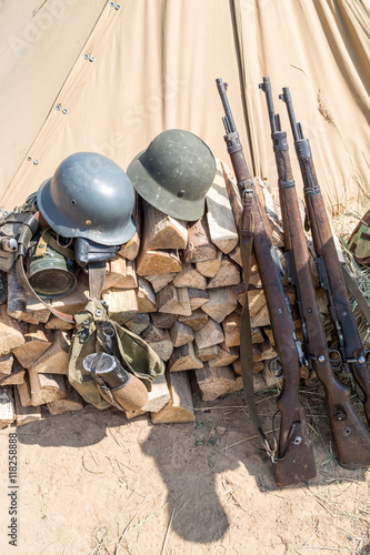 rifles, ammunition and helmets lay on the woodpile photo