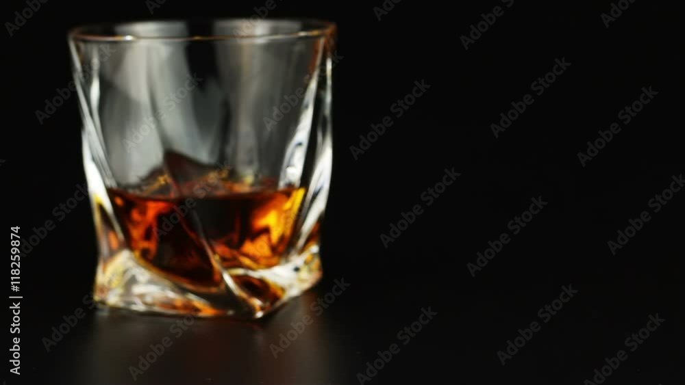Young man drinking whiskey over black background Young man drinking whiskey over black background
