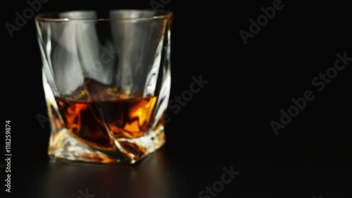Young man drinking whiskey over black background