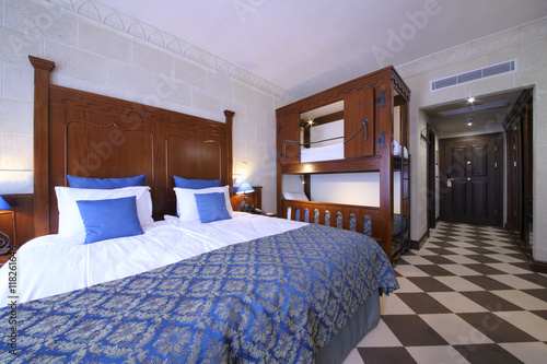 Interior of superior room with a double bed and a bunk bed in the Hotel Bogatyr