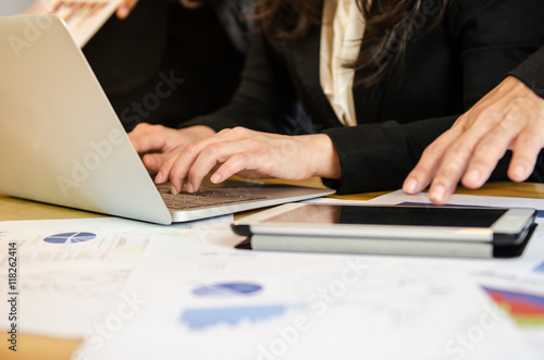 Close up business woman typing on laptop in meeting room