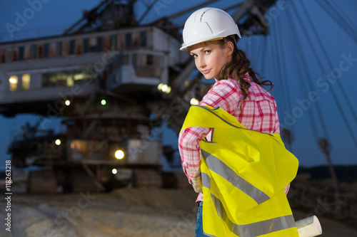 female worker standing with scheme on rails on backgroud of career stacker