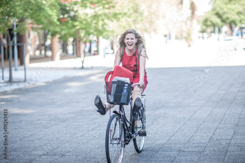 Happy businesswoman freewheeling on bicycle in city photo