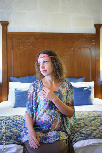 Portrait of woman in ethnic dress sitting on a bed photo