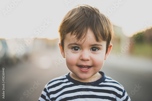 happy brunet kid smiling at camera photo
