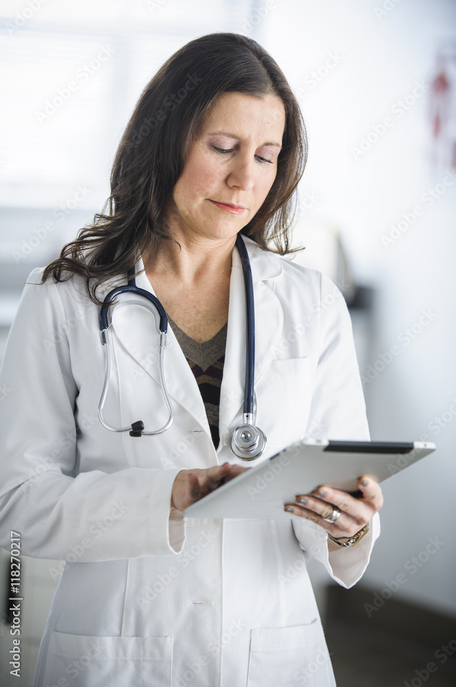 Caucasian doctor using tablet computer in office Caucasian doctor using tablet computer in office