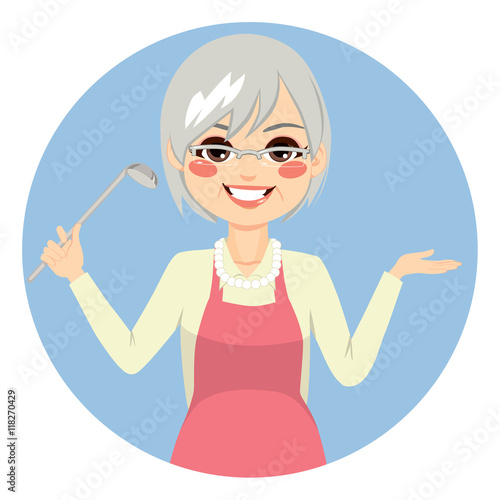 Happy granny cooking with apron holding kitchen spoon